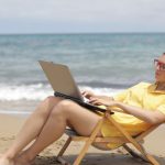 Computer Beach - Woman in Yellow Shirt Sitting on Brown Wooden Folding Chair on Beach