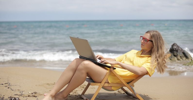 Computer Beach - Woman in Yellow Shirt Sitting on Brown Wooden Folding Chair on Beach