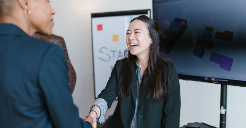 Network Handshake - Woman in Black Blazer Smiling