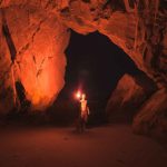 Torch Shadow - Person Standing and Holding Lamp Inside Cave