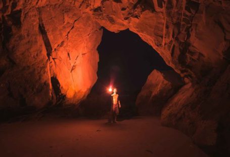 Torch Shadow - Person Standing and Holding Lamp Inside Cave