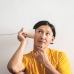 Puzzle People - Pensive ethnic man listening to answer in paper cup phone