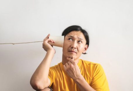 Puzzle People - Pensive ethnic man listening to answer in paper cup phone