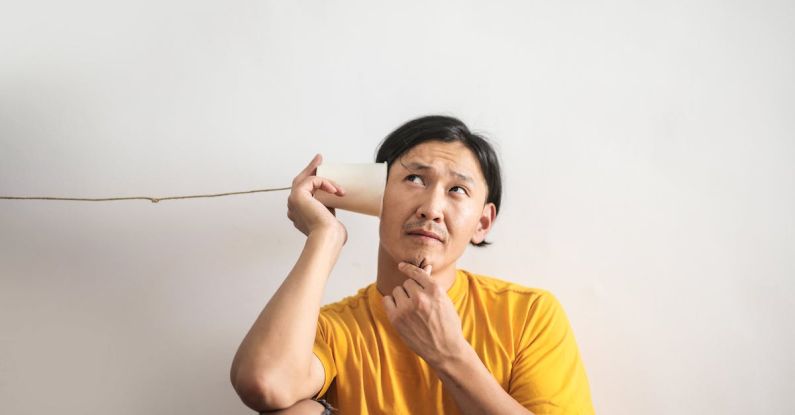 Puzzle People - Pensive ethnic man listening to answer in paper cup phone