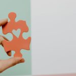 Puzzle Hand - Close-up of Person Holding a Puzzle Piece with a Heart