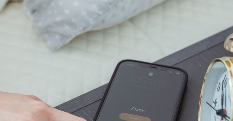 Phone Off - From above of hand of crop anonymous female turning off alarm on mobile phone in bedroom in morning time