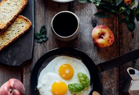 Fork Apple - Top view of fried eggs with mint in pan near fruits and bread on wooden table