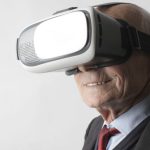 Watch Futuristic - Smiling elderly gentleman wearing classy suit experiencing virtual reality while using modern headset on white background