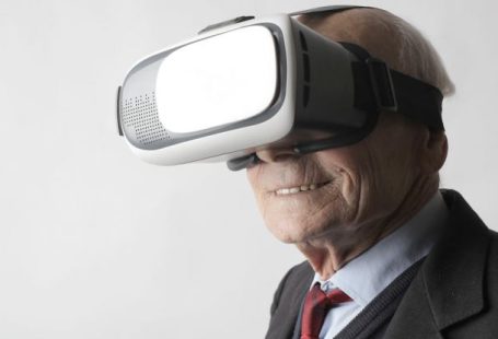 Watch Futuristic - Smiling elderly gentleman wearing classy suit experiencing virtual reality while using modern headset on white background