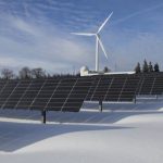 Wind Solar - Solar Panels on Snow With Windmill Under Clear Day Sky