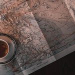Money Book - White Ceramic Cup on Map