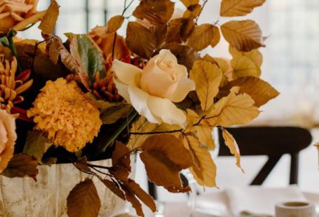 Fork Leaf - Elegant floral composition in vase placed on white table with ceramic plates and golden cutlery during festive banquet