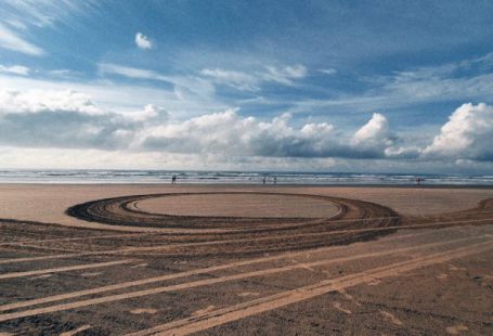 Footprint Earth - A circular track on the beach with a large sand dune
