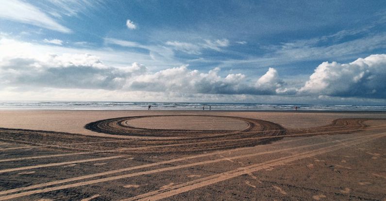 Footprint Earth - A circular track on the beach with a large sand dune