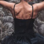 Forest Therapy - A woman in black dress sitting in the woods