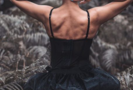 Forest Therapy - A woman in black dress sitting in the woods
