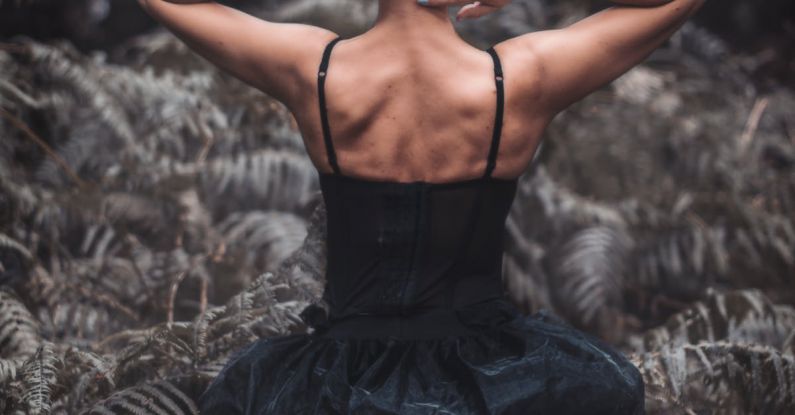 Forest Therapy - A woman in black dress sitting in the woods