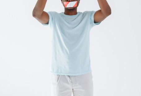 Tape Mouth - Man with Mouth Tape Holding a Stop Signage