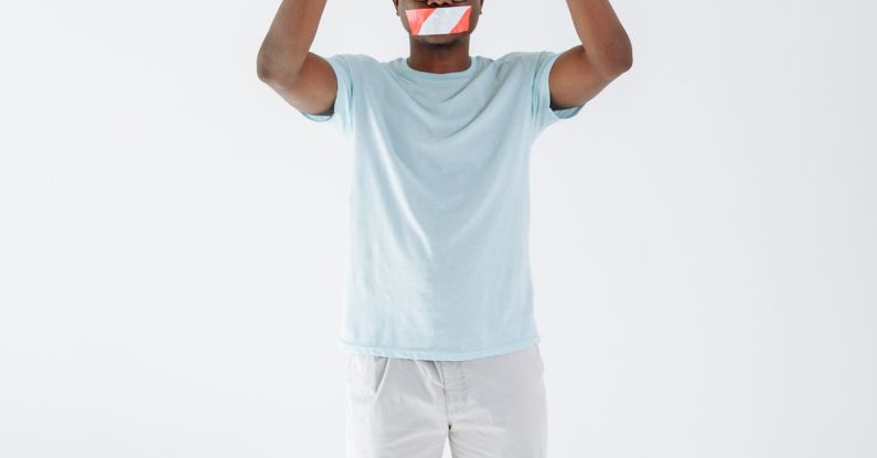 Tape Mouth - Man with Mouth Tape Holding a Stop Signage