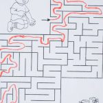 Paint Brain - Top view of solved labyrinth test with little boy and boots painted on paper placed on white desk with red pen